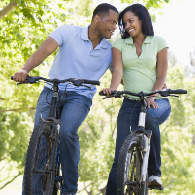 Couple on bikes outdoors smiling