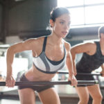 Female athlete exercising with fitness bar